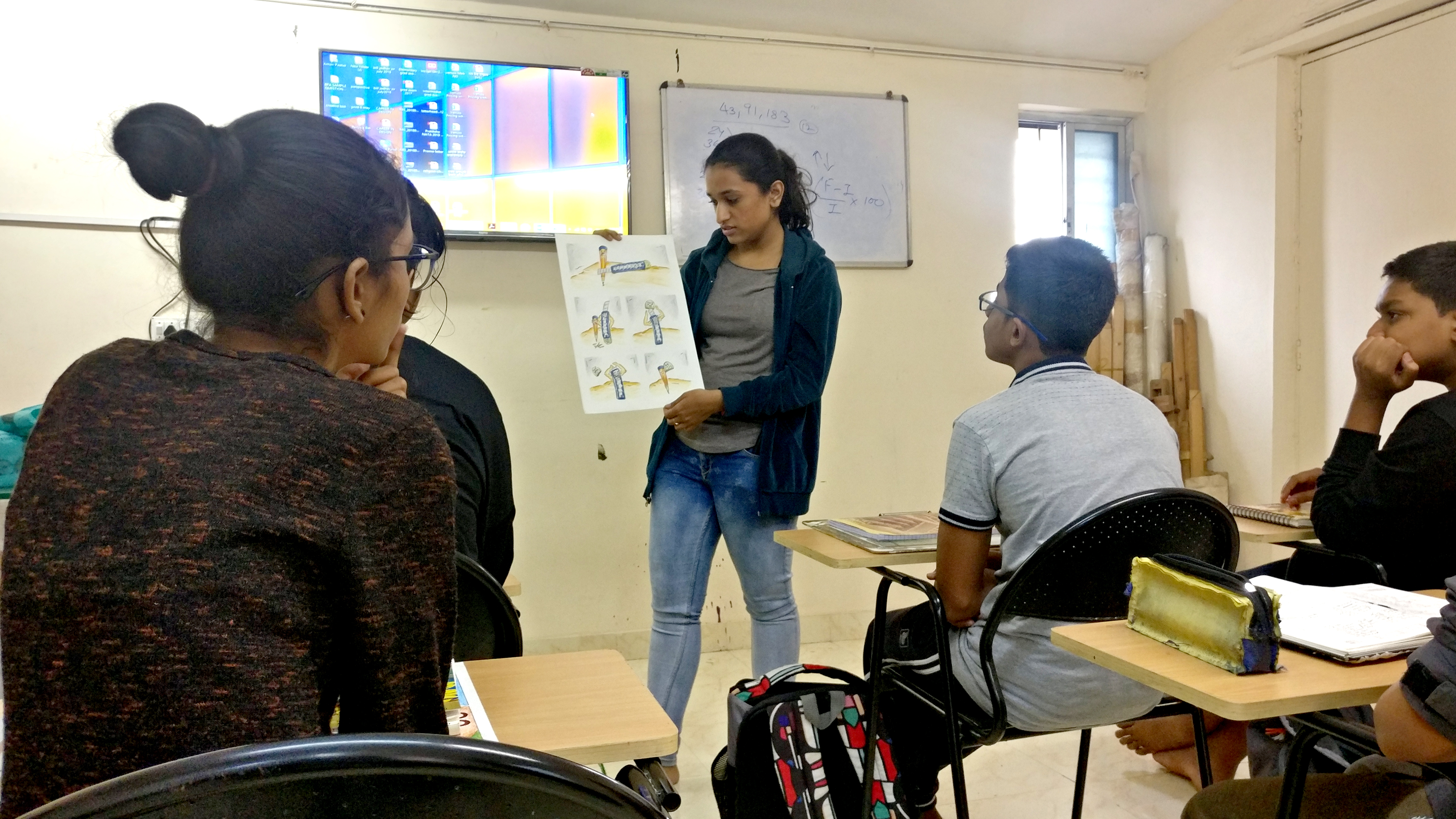Students sketching at drawing tables in the CheetraKul studio classroom